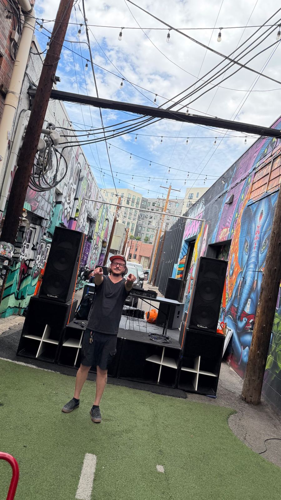 The alley at Tracks Denver set up under string lights between mural-covered walls, with Harambe out front